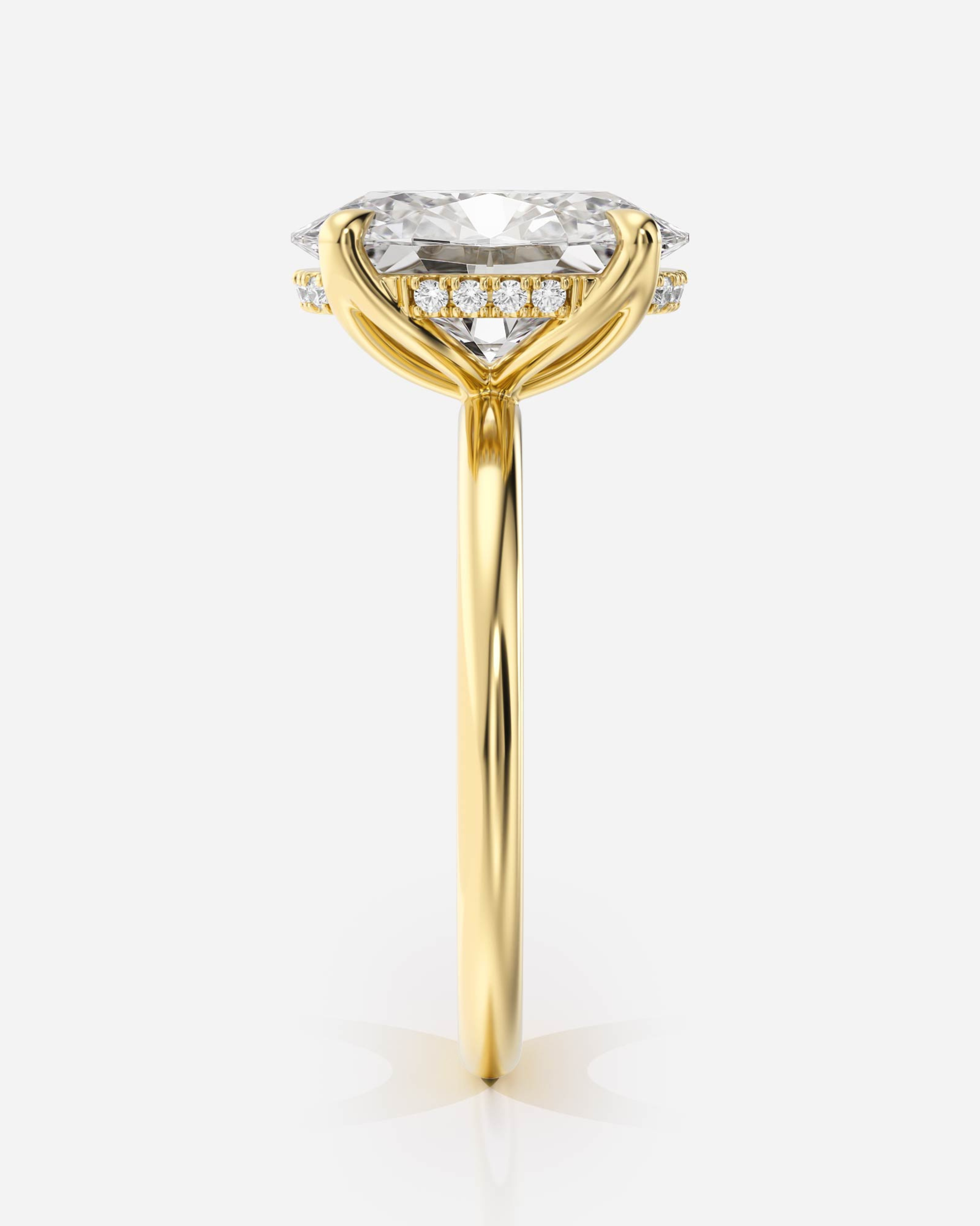 Eleonora Solitär Hidden Halo förlovningsring i 18K guld, sidovy med hidden halo och skulptural klofattning